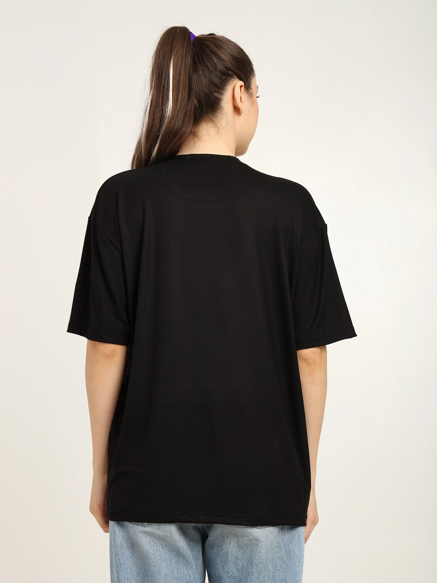 Person wearing a black t-shirt with a plain background