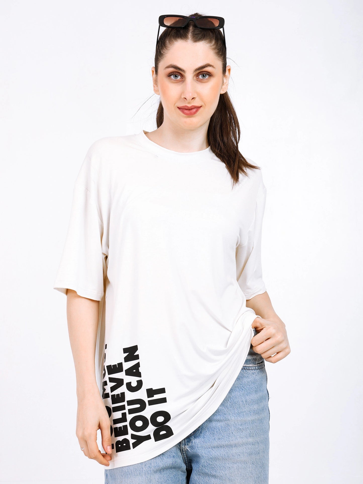 Woman wearing a soft, oversized bamboo T-shirt with motivational print in a stylish streetwear look.