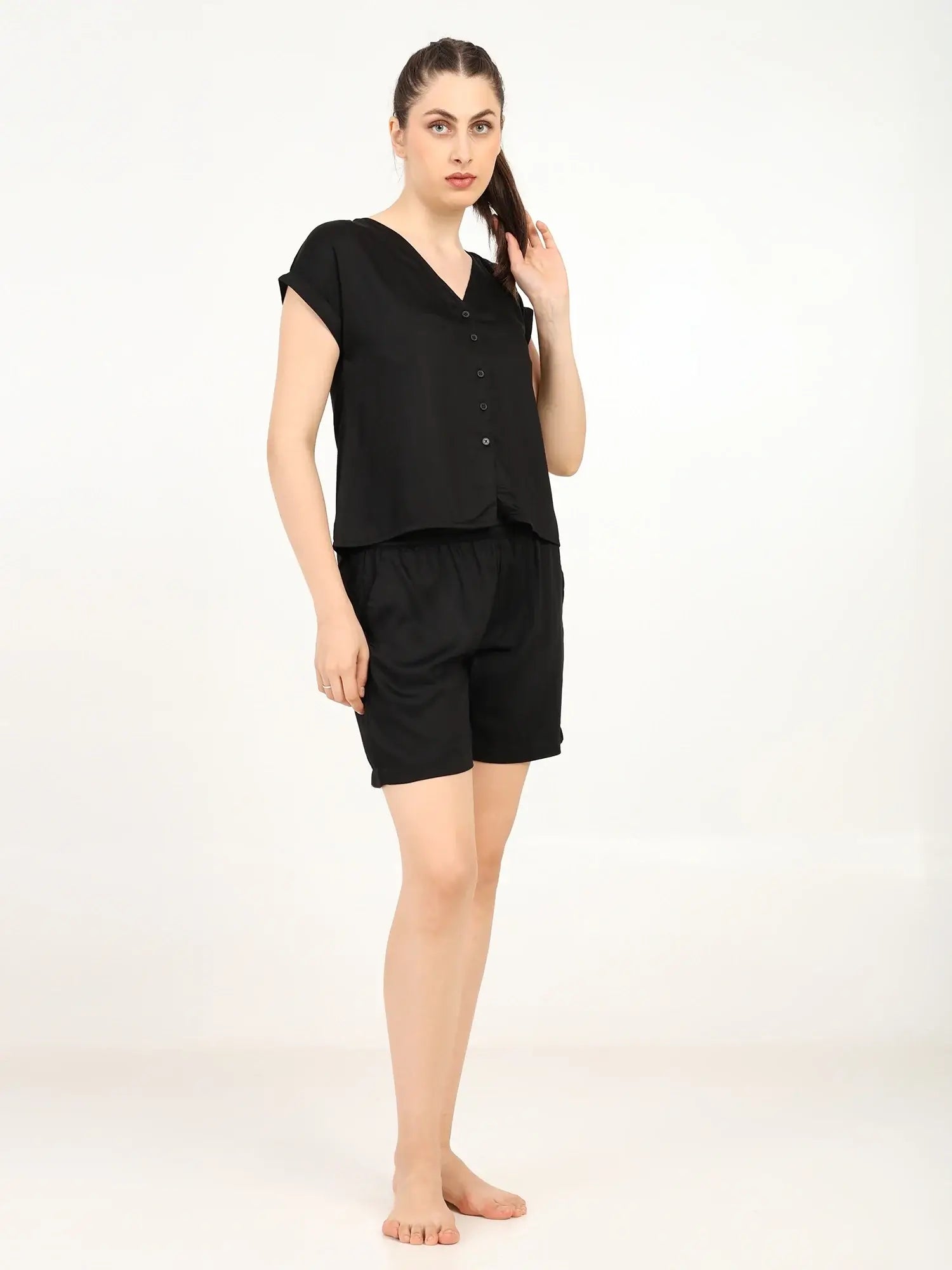 Model wearing Women's Modal Satin Night Suit in black, featuring a soft shirt and shorts for ultimate comfort.