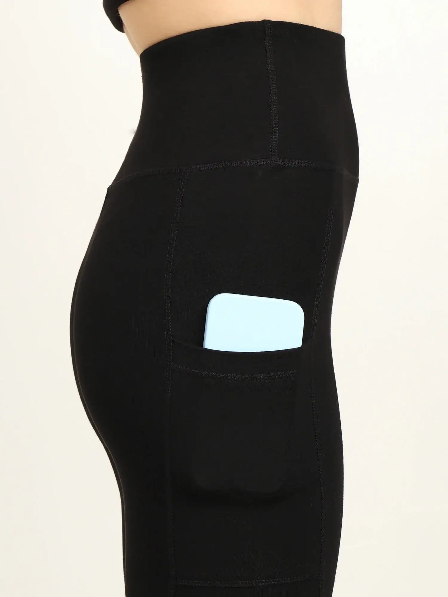 Side view of high-waist bamboo yoga pants with pocket, featuring a phone tucked inside for convenience and style.