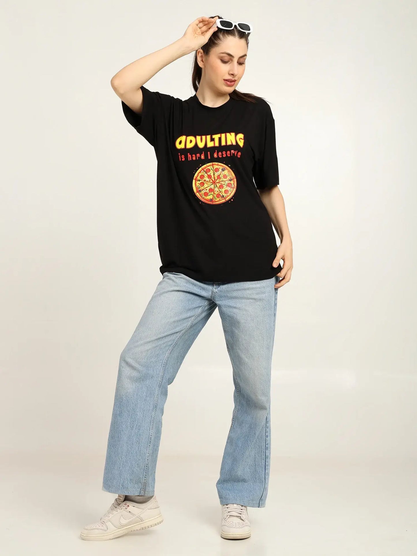 Person wearing a black t-shirt with a graphic design and text, standing against a plain background