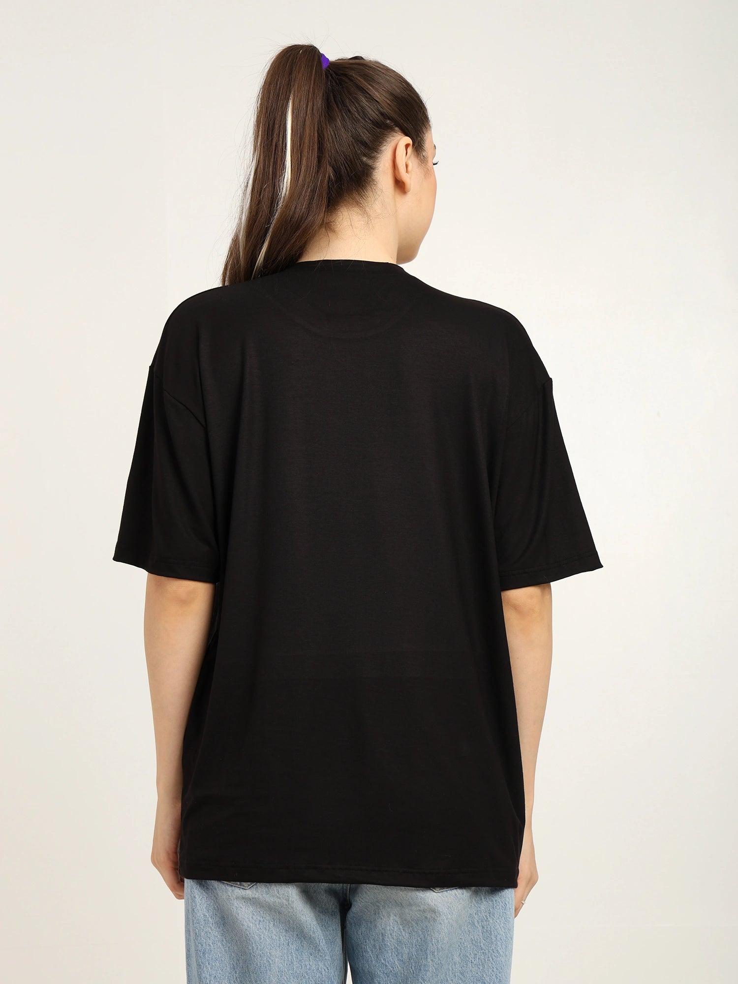 Person wearing a black t-shirt with a plain background