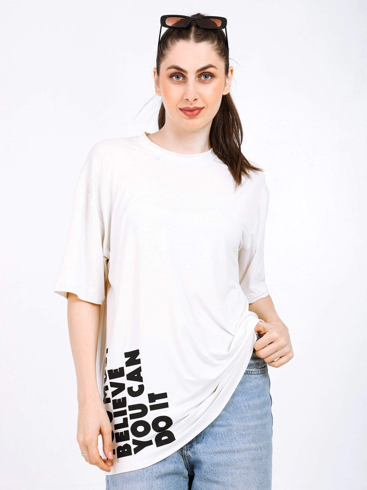 Woman wearing a soft, oversized bamboo T-shirt with motivational print in a stylish streetwear look.