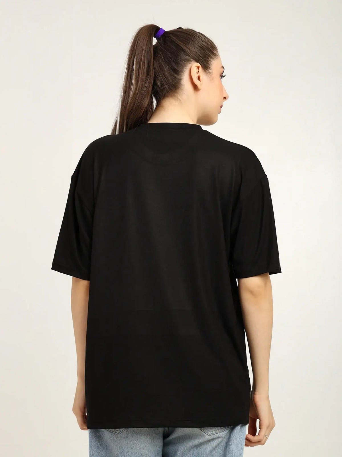 Person wearing a black t-shirt on a plain background