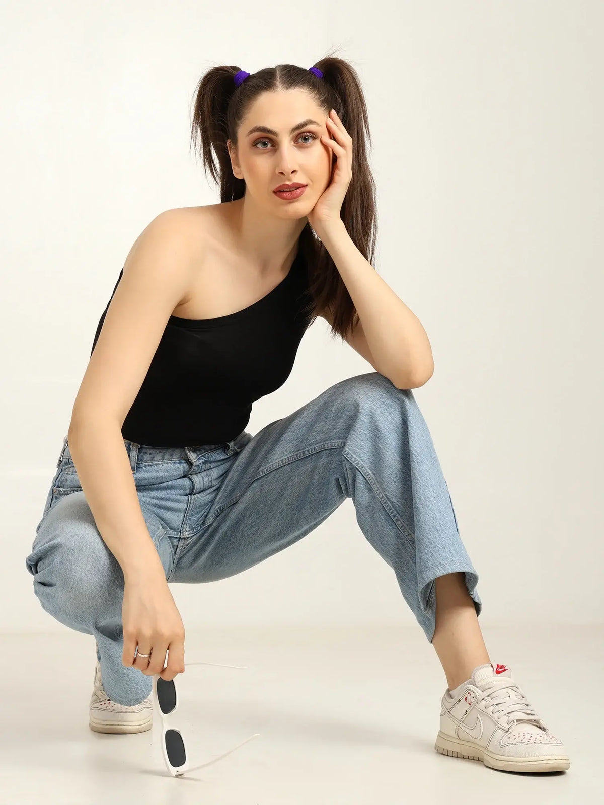 Gen Z woman in a one-shoulder bamboo top and baggy jeans, showcasing effortless style and sustainable fashion.