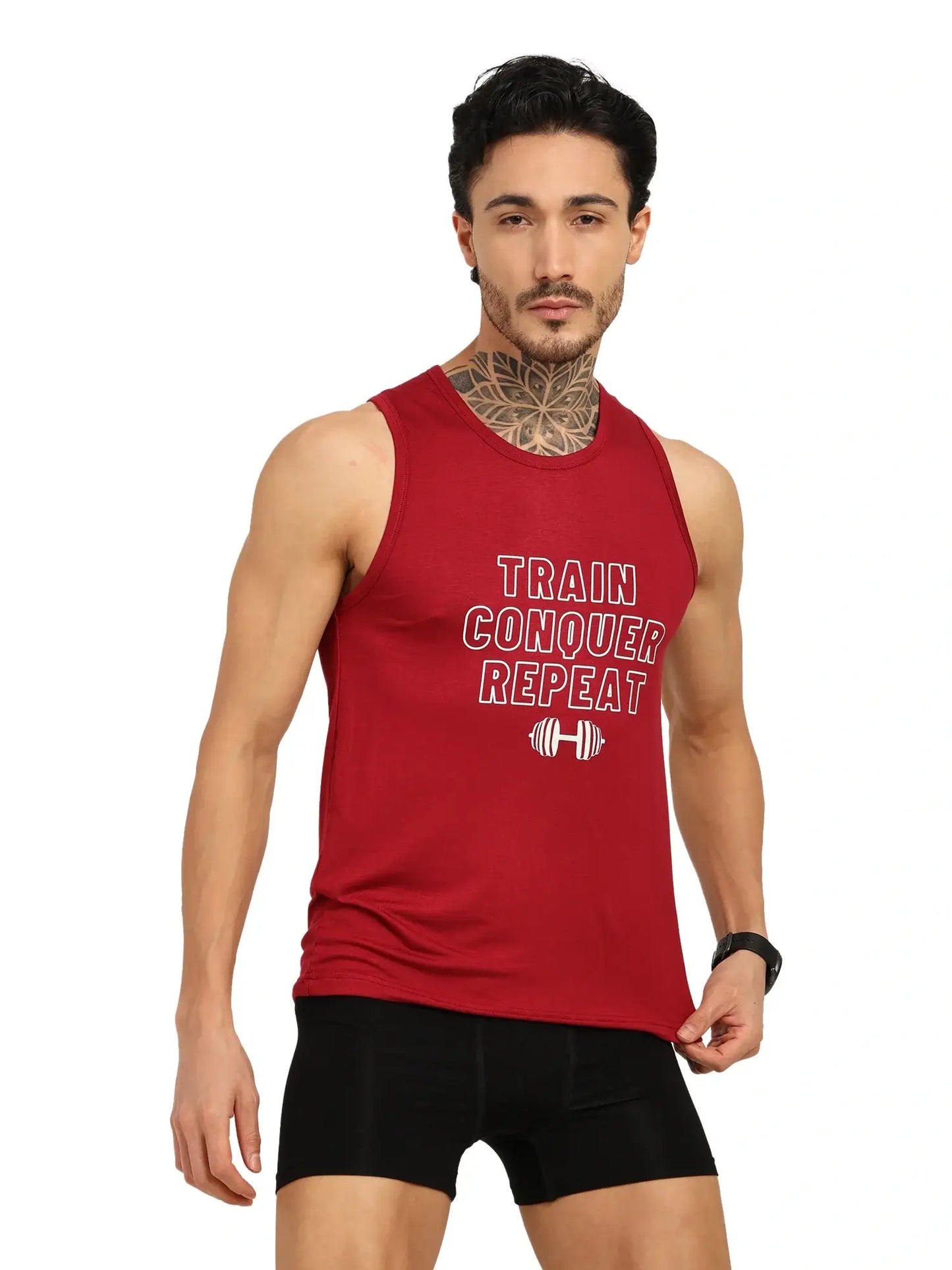 Model wearing a red training tank top with 'Train Conquer Repeat' slogan, showcasing fitness apparel style.