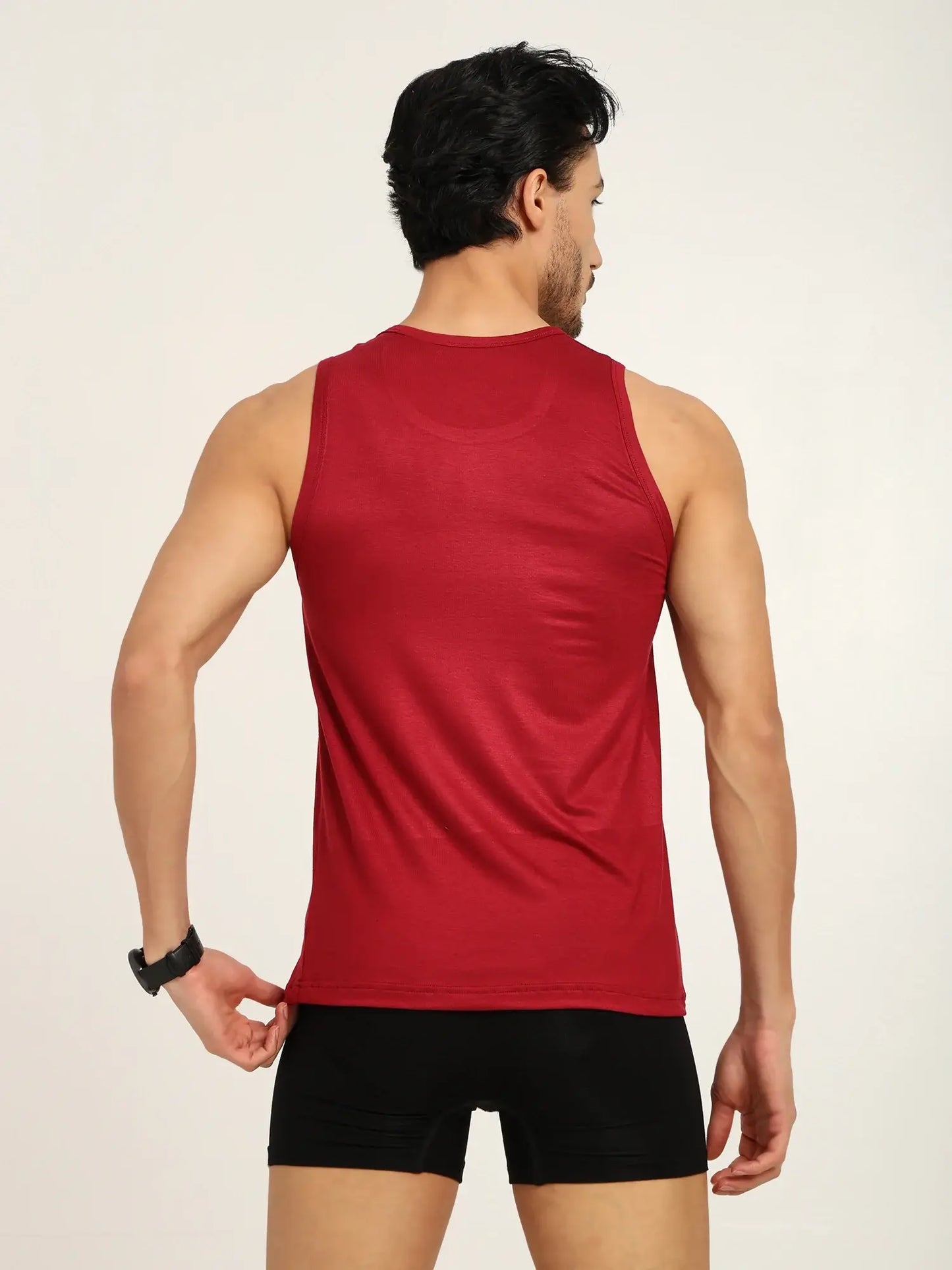 Rear view of a man wearing a red tank top and black trunks, showcasing comfort and style in men's activewear.