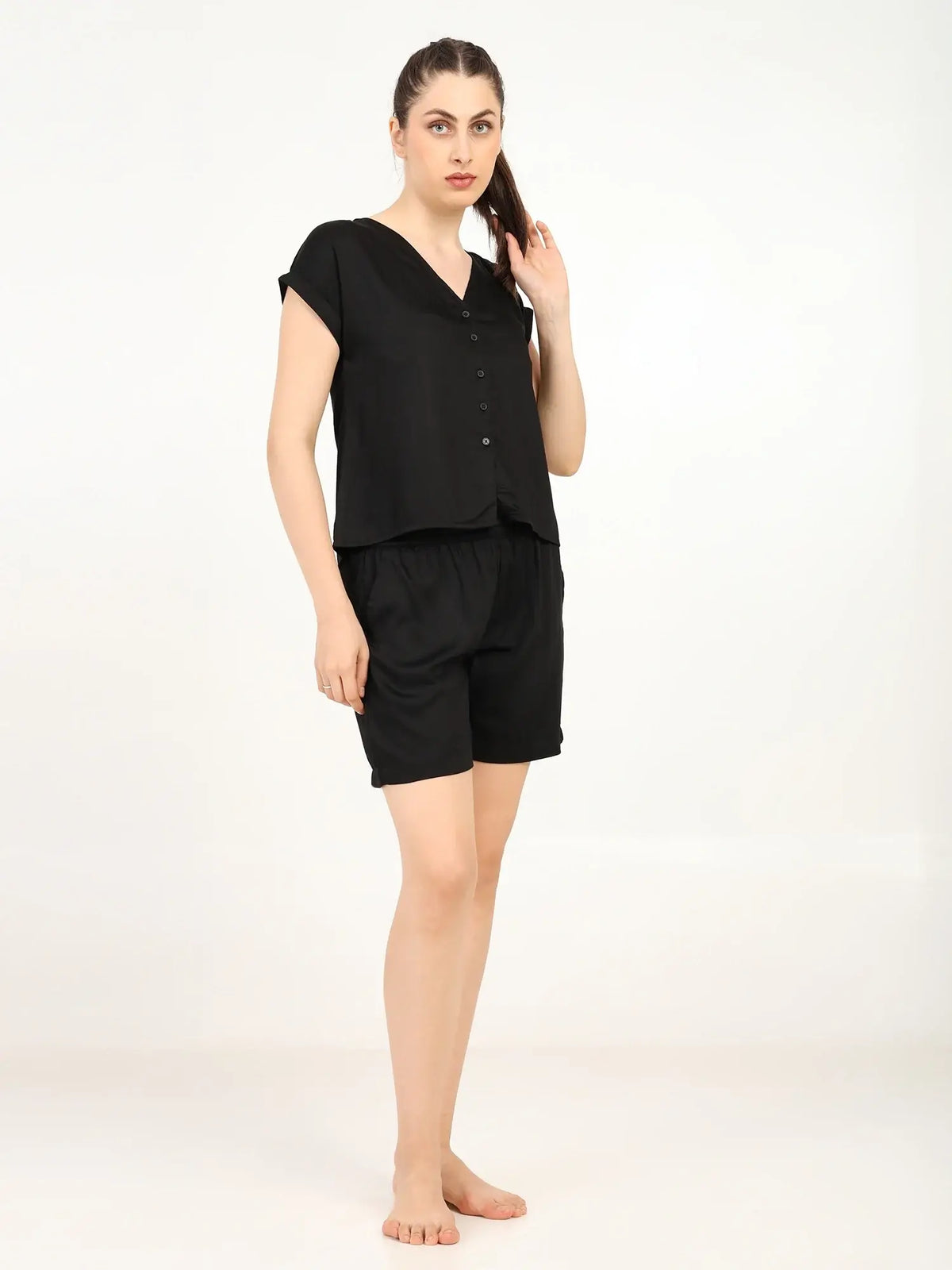 Model wearing Women's Modal Satin Night Suit in black, featuring a soft shirt and shorts for ultimate comfort.
