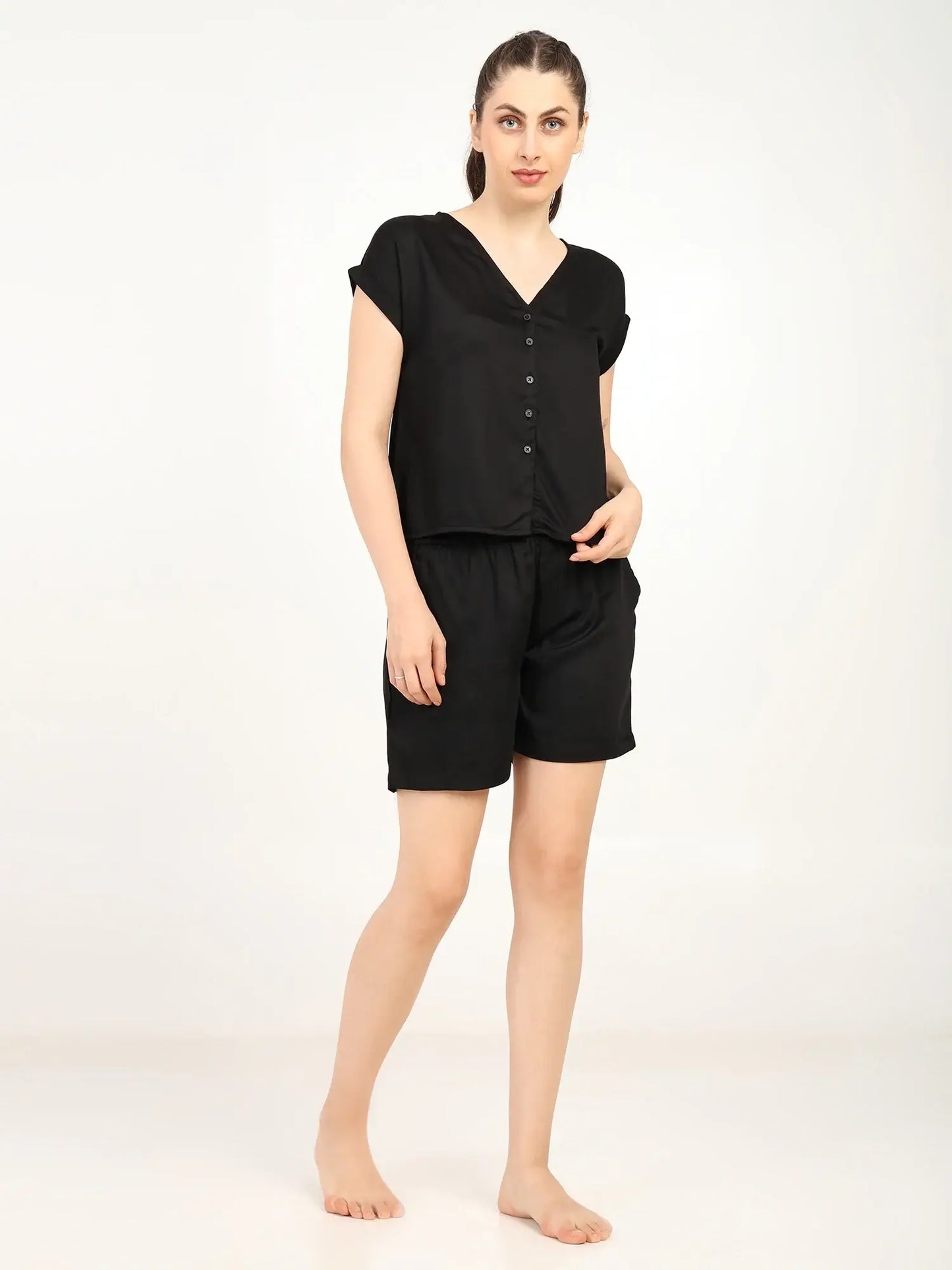 Model wearing Women's Modal Satin Night Suit in black, featuring a soft button-up shirt and shorts, perfect for sleepwear.